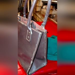 A Wilson Leather Rich Brown Leather purse medium size thee zippers in side.